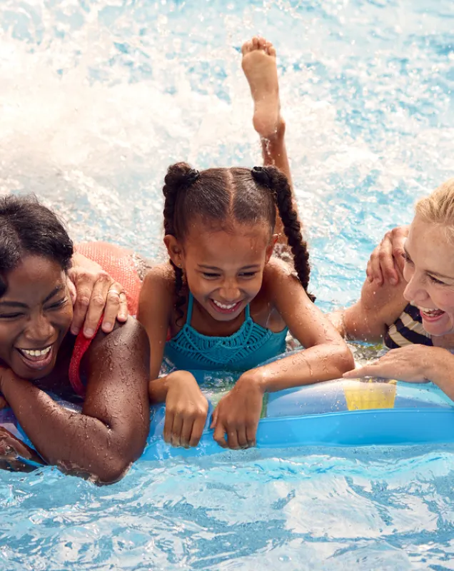 Groupe de 5 personnes souriantes dans une piscine